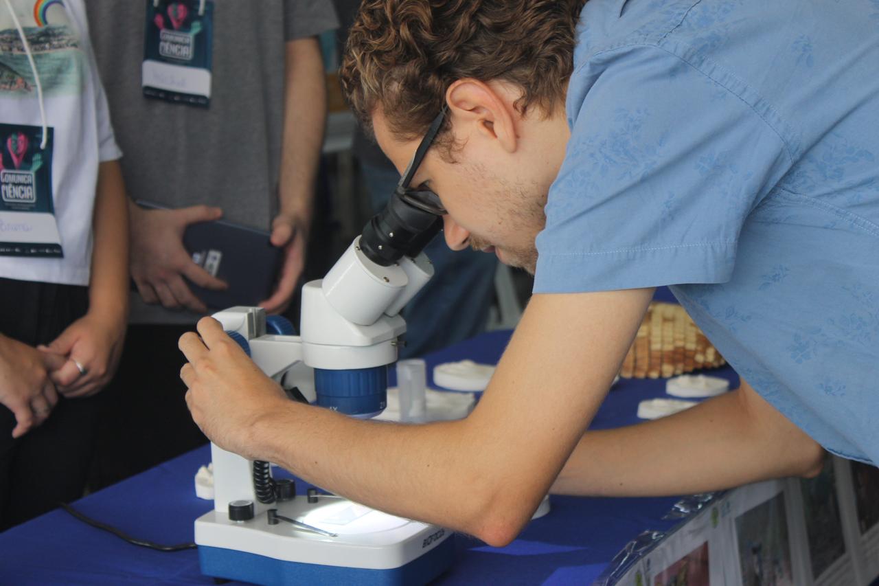 Menino olhando no microscópio