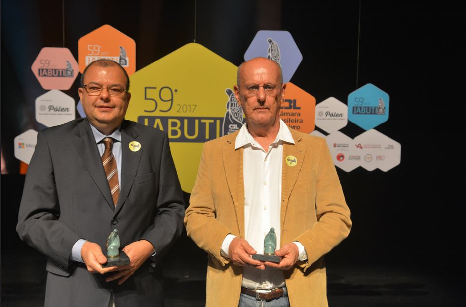 Imagem de dois homens segurando troféu do Prêmio Jabuti: à esquerda, o diretor da série, o professor Décio Gatti Júnior; à direita, o autor do livro, Carlos Monarcha