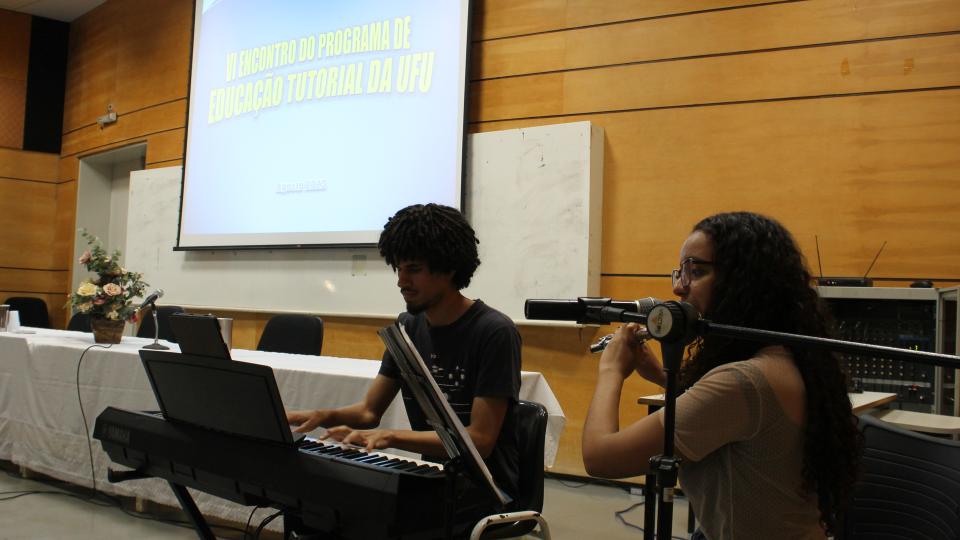 Dois estudantes fazendo apresentação cultural musical