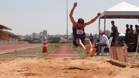 Atleta homem saltando na prova de salto em distância