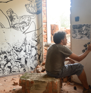 Glayson Arcanjo fazendo uma intervenção artística dentro de uma casa em demolição.