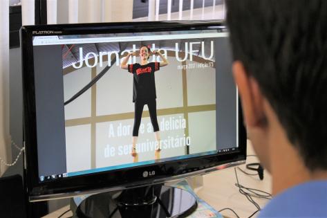 Servidor da UFU lê o Jornal da UFU em tela de computador.