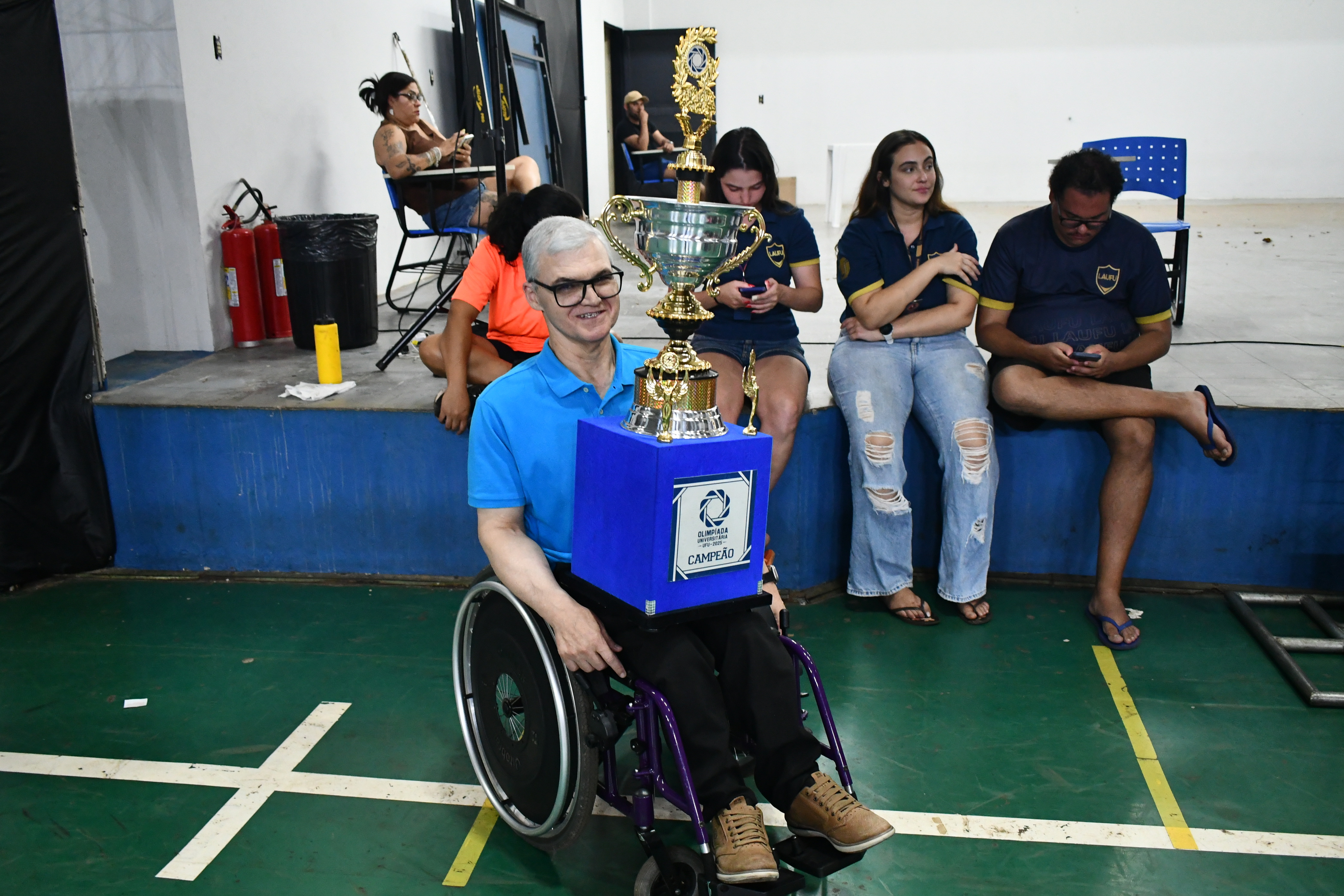 Reitor Professor Carlos Henrique de Carvalho segurando troféu de campeão da Olímpiada UFU  