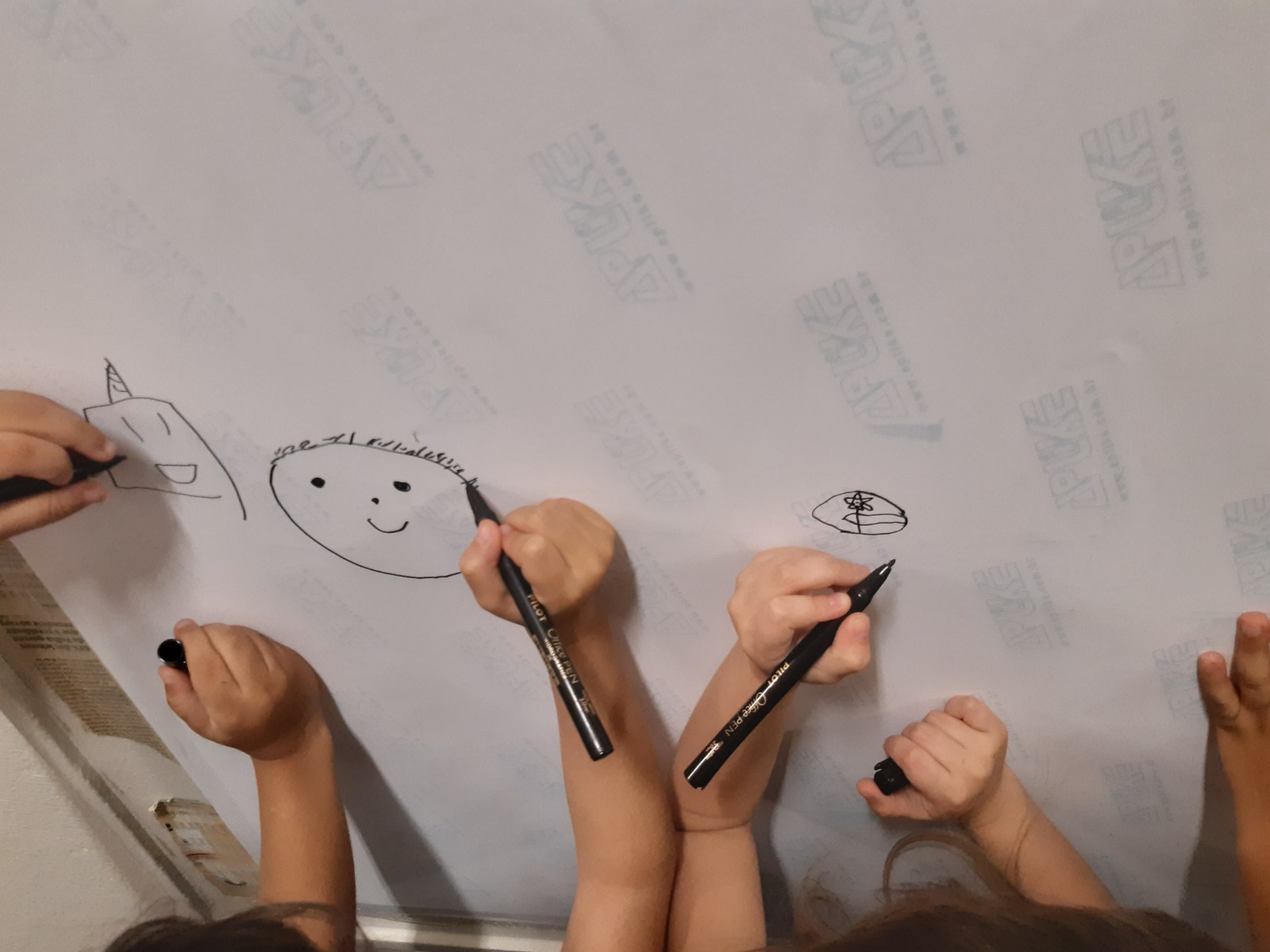 Mãos de crianças desenhando no papel