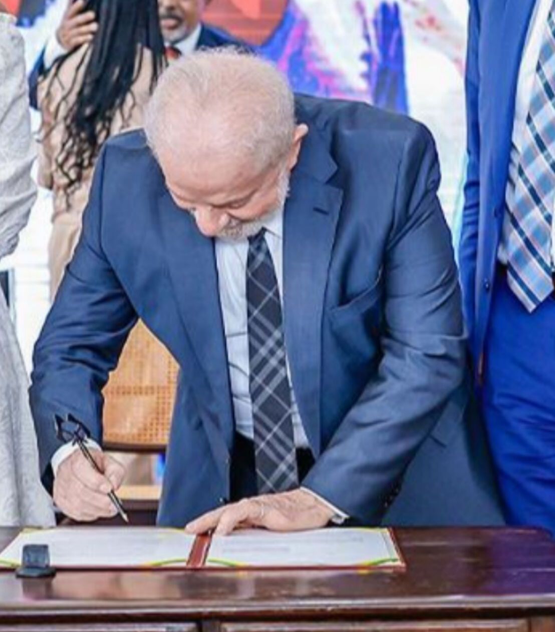 Imagem do presidente assinando o documento com a caneta artesanal