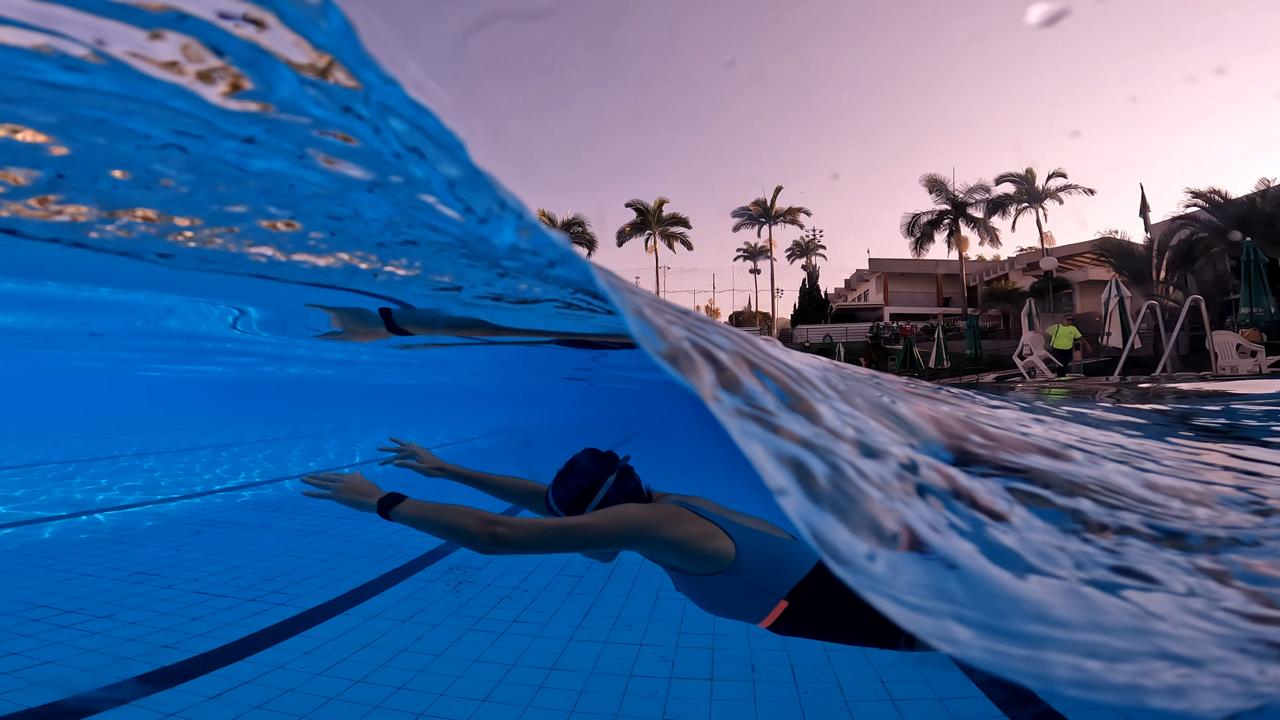 Mulher mergulhando na piscina durante o fim da tarde