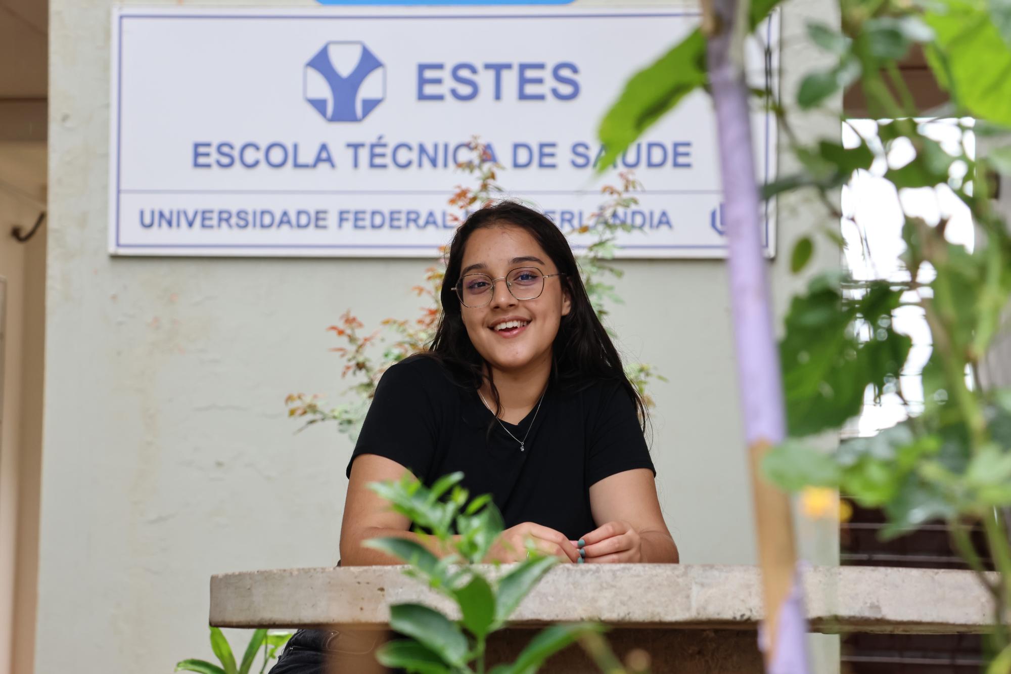 A aluna Isabel Pereira de Alen em frente a placa da Estes