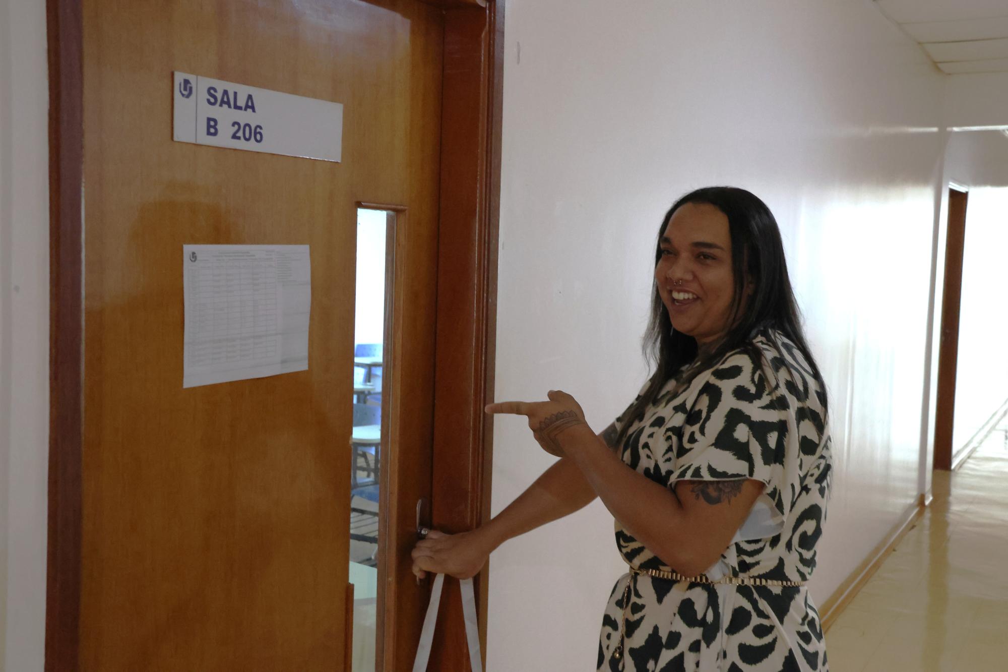 Luiza abrindo a porta da sala B 206