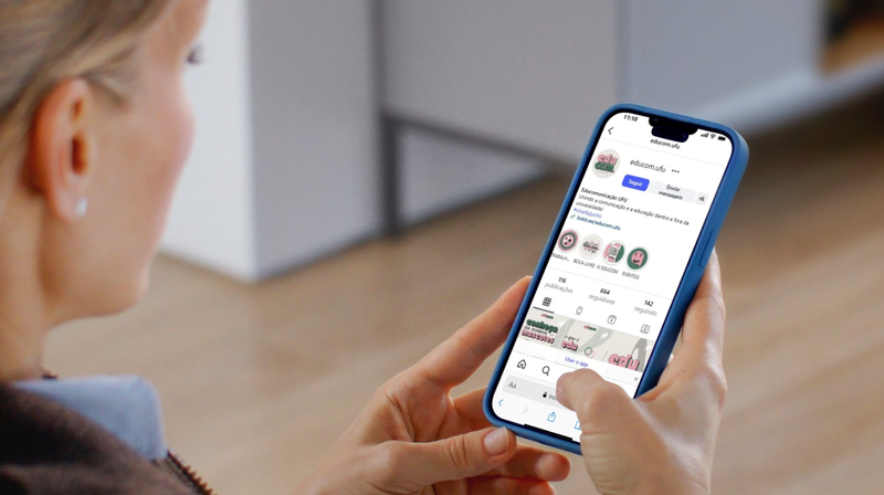 Mulher consulta Instagram do Educom UFU