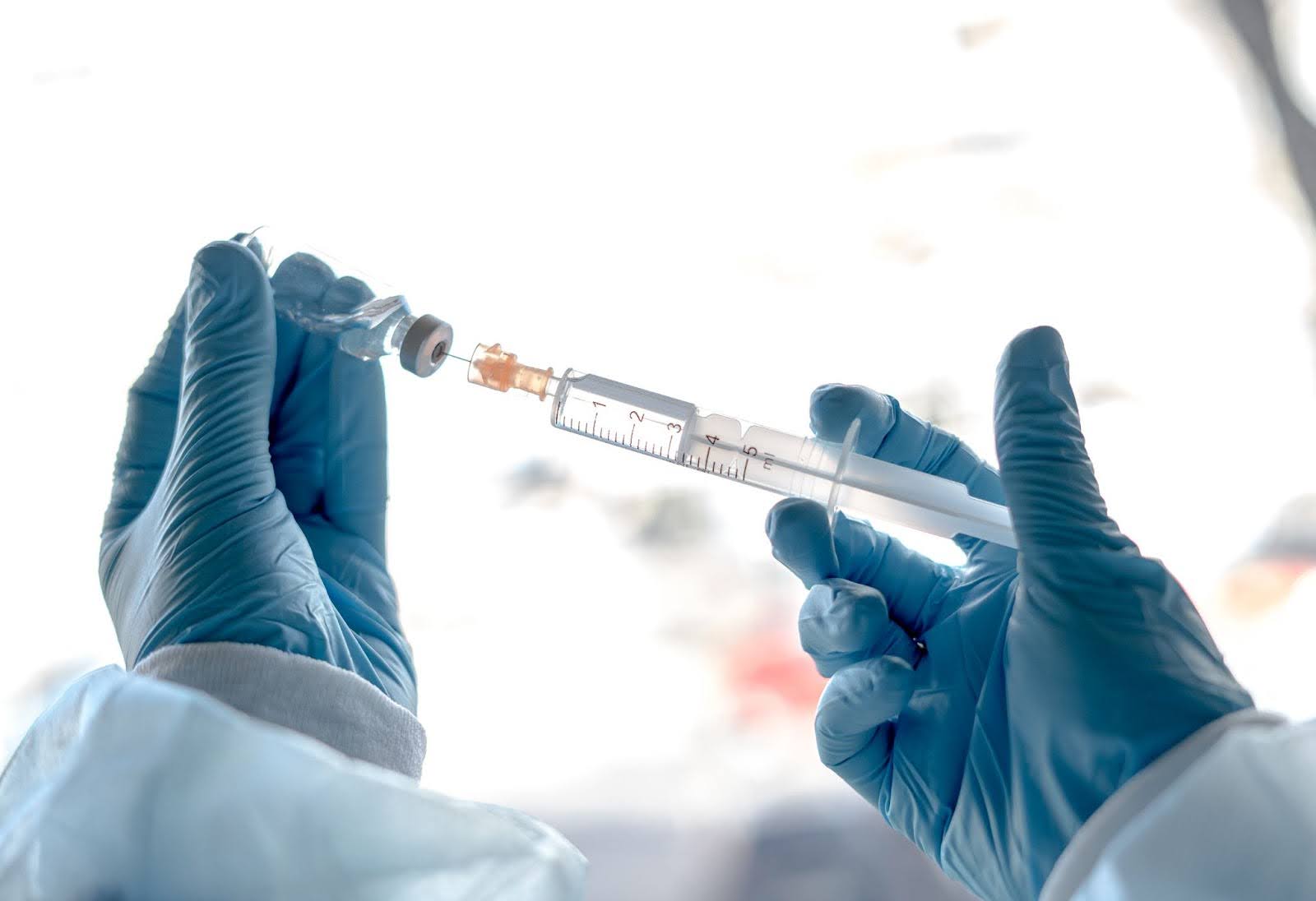 Mão com agulha e ampola