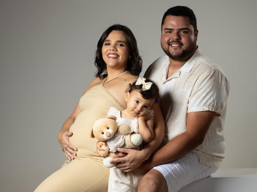 Uma família formada por um homem, uma mulher grávida e uma menina pequena