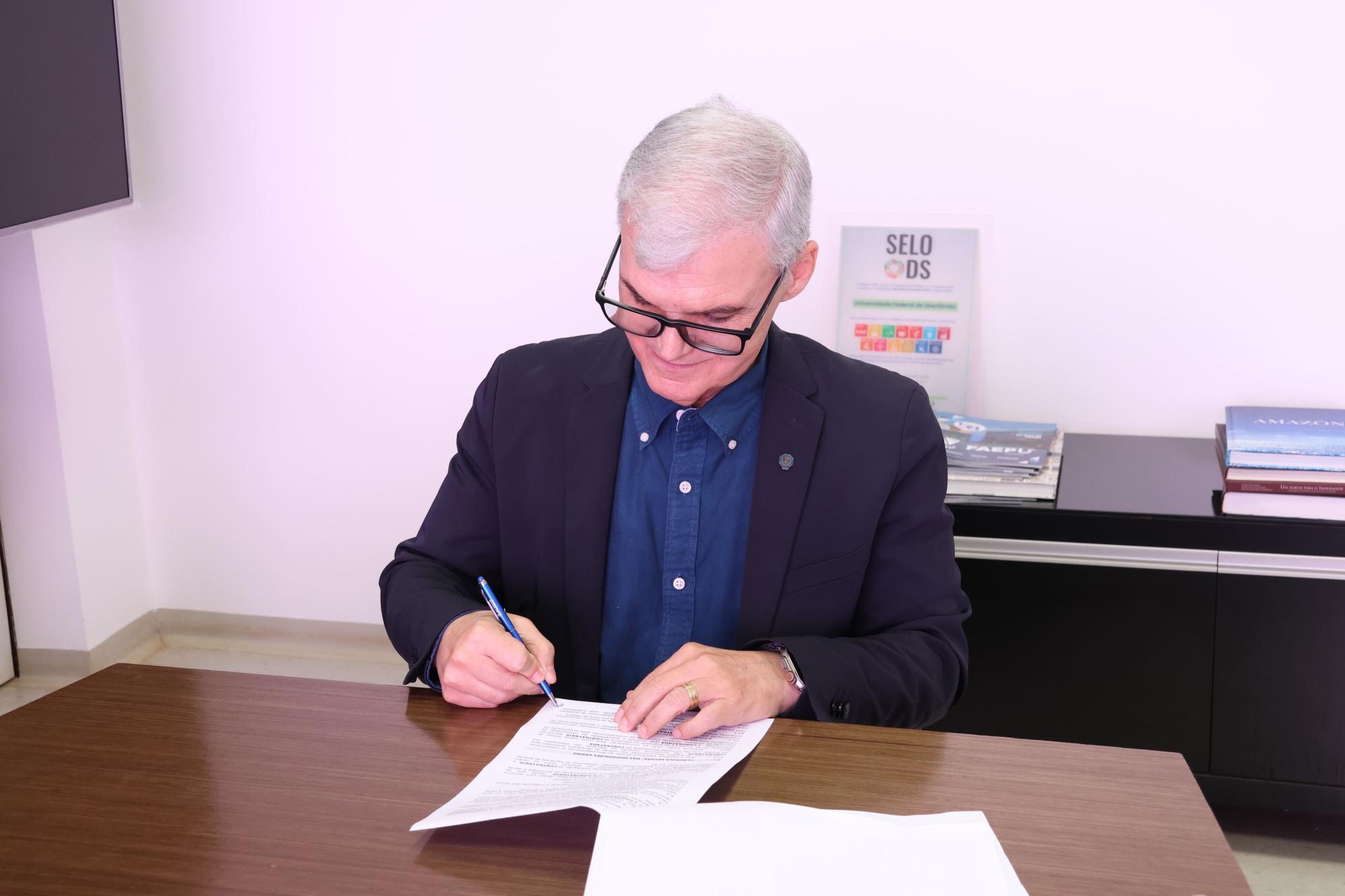 Reitor da UFU assinando o contrato de parceria