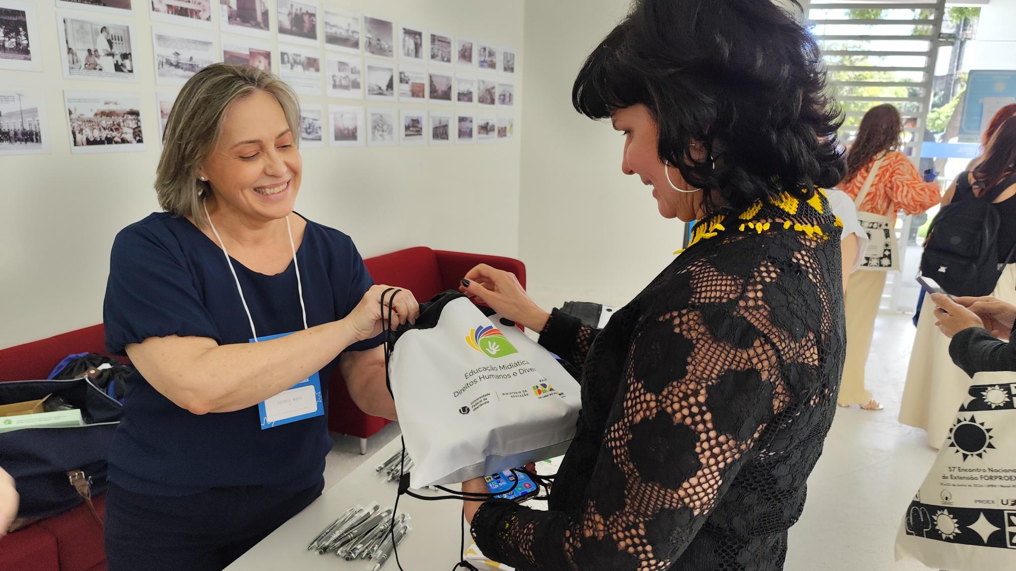 Valéria Rodrigues entrega materiais didáticos produzidos nos cursos do projeto