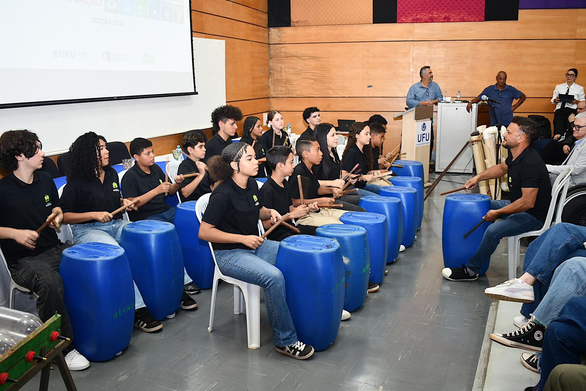 Participantes do Instituto Alexa realizando a apresentação com instrumentos feitos com materiais recicláveis