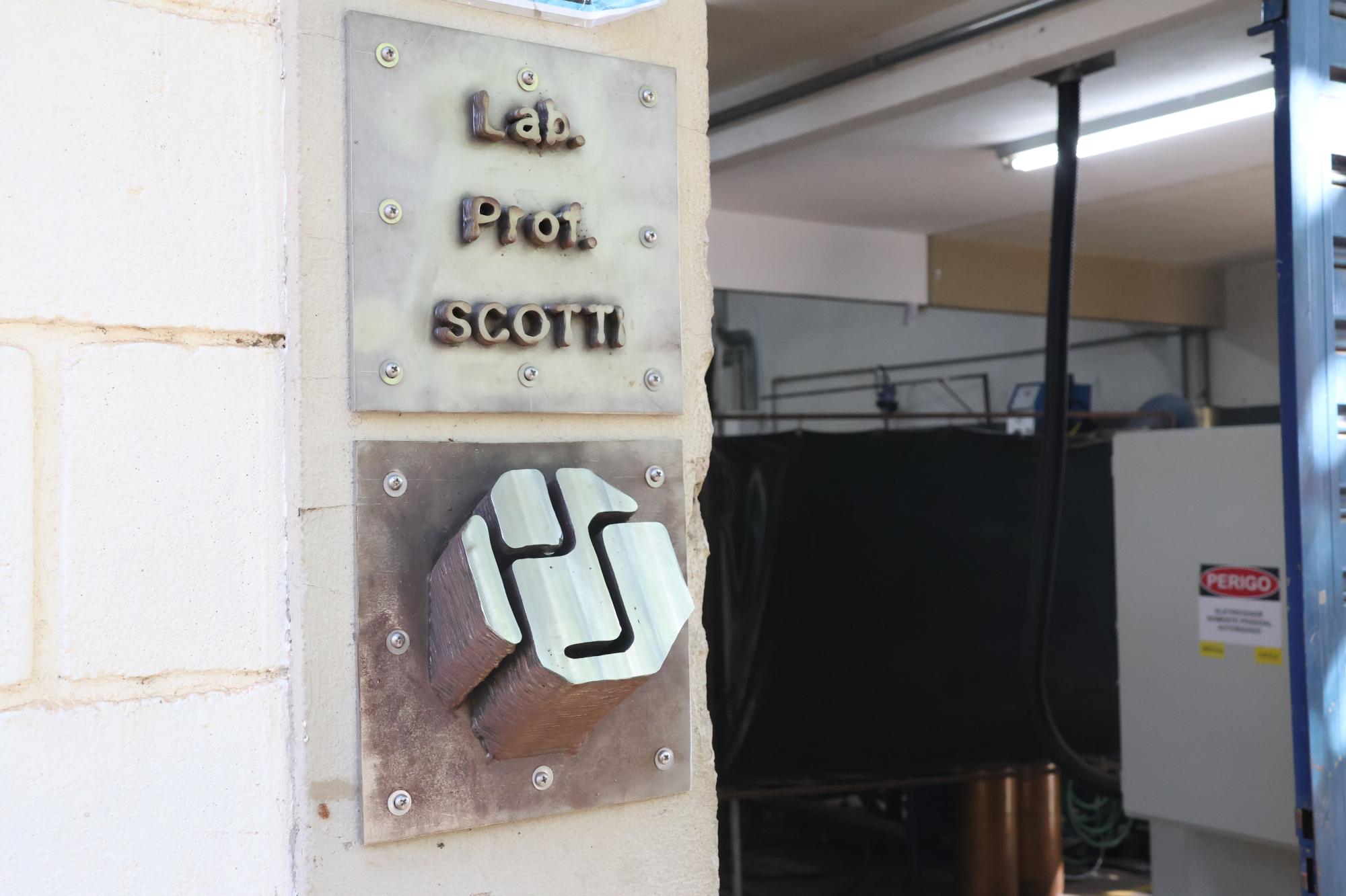 Logomarca produzida em aço, em frente ao laboratório.