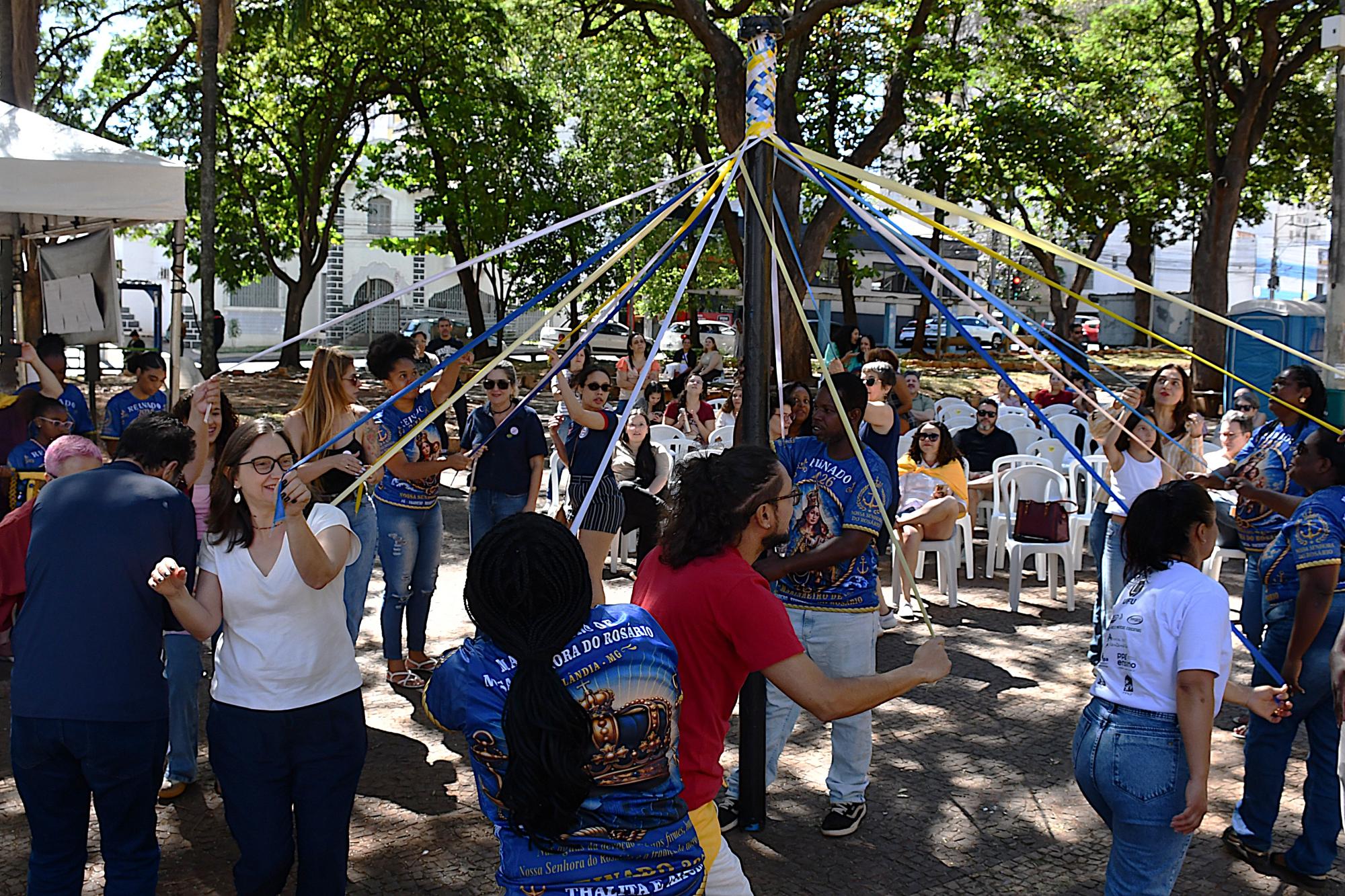 Participantes da aula pública participam da dança do trançar das fitas