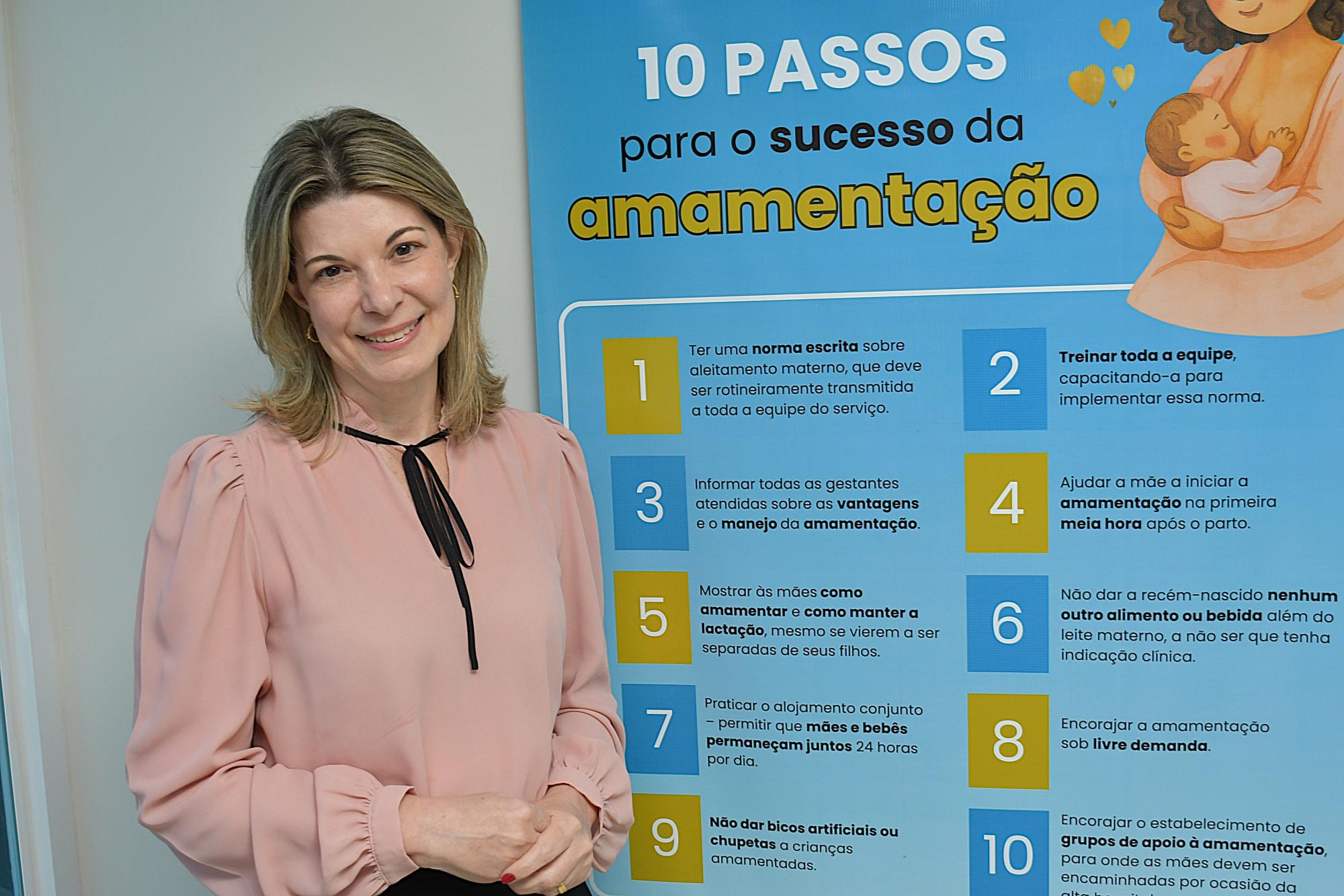 Mulher em frente a banner com informaçõe sobre os dez passos para o sucesso do aleitamento materno. (Foto: Milton Santos)
