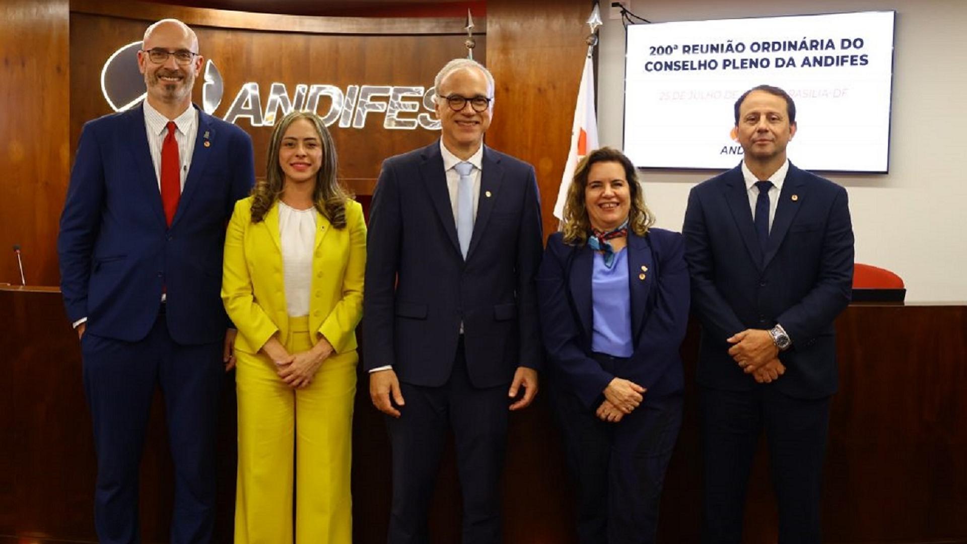 Foto oficial da nova equipe gestora da Andifes; são três homens e duas mulheres; todos estão de pé e posando para a foto oficial