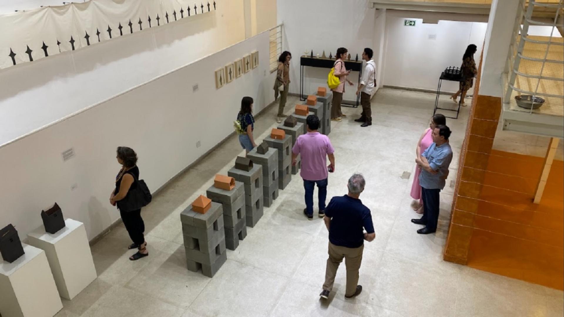 Imagem aberta mostrando 10 pessoas no hall de um museu