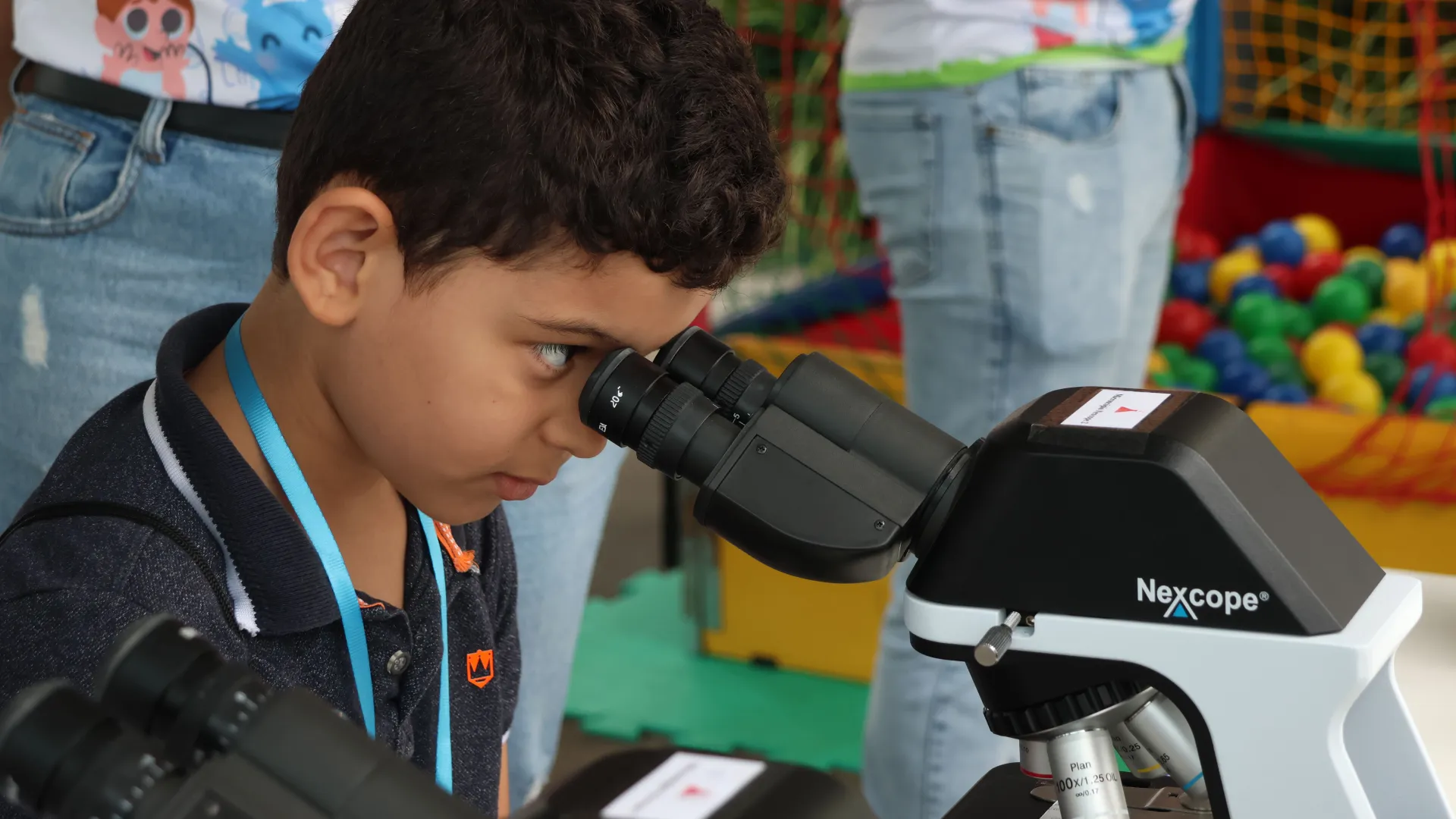 Criança olhando no microscópio