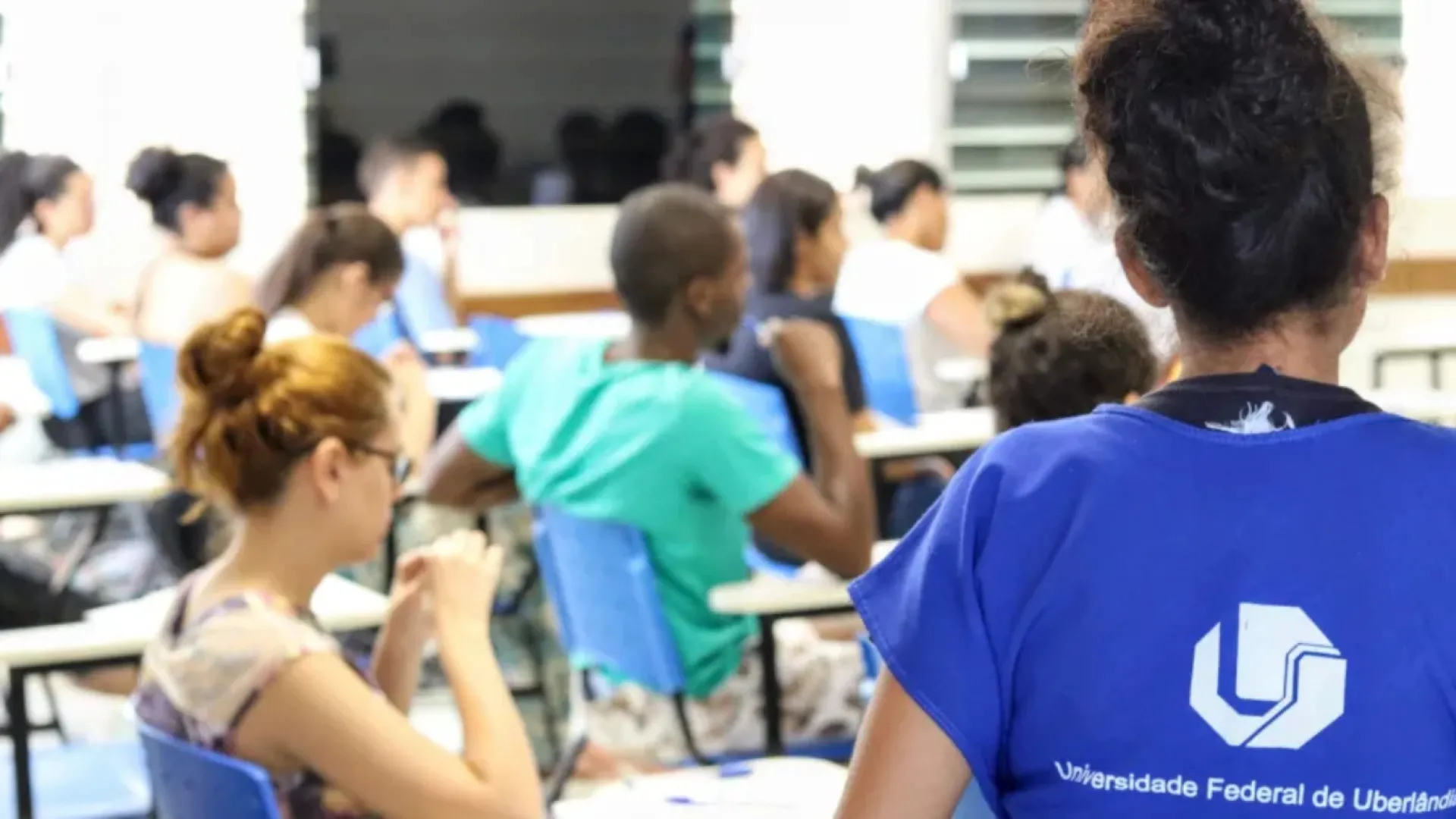 Imagem de uma sala de aula tendo aplicação de prova