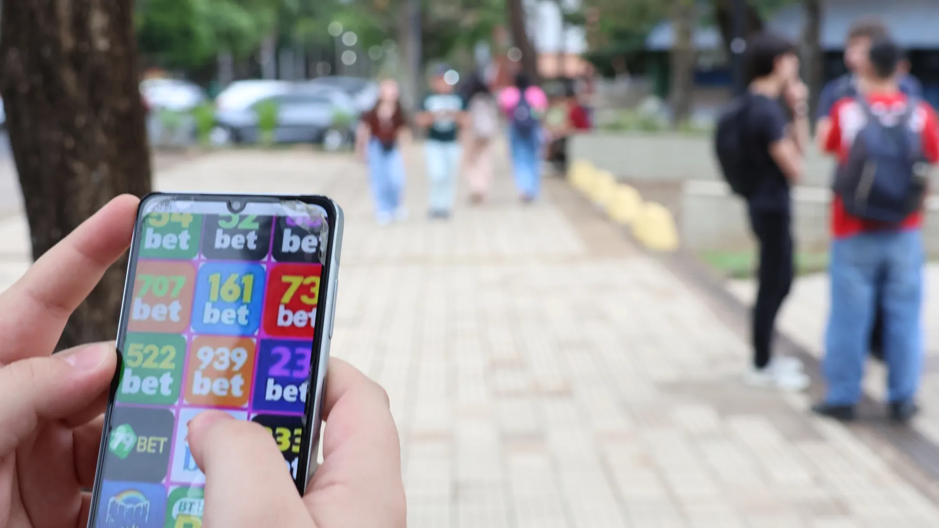 Jovem aposta no celular na universidade