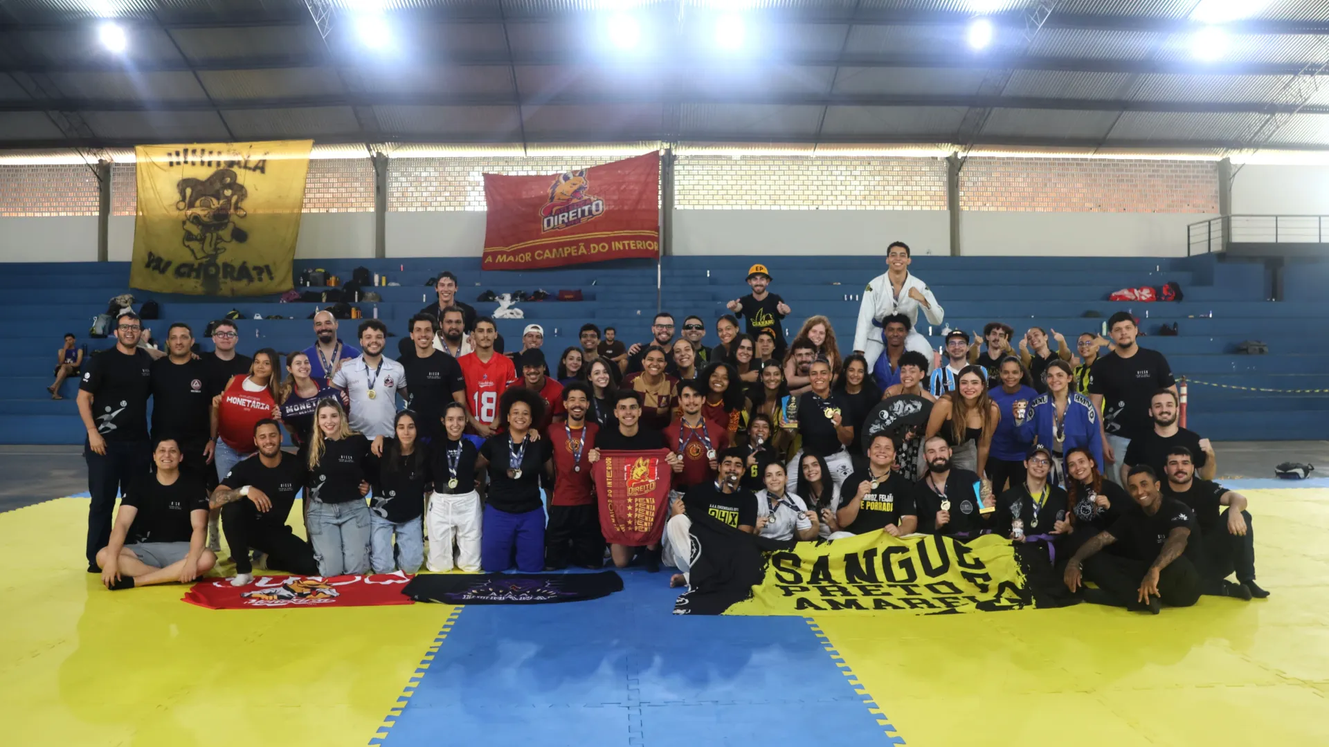 Atletas de Jiu-jitsu da UFU e organização do evento de competição da modalidade reunidos no tatame