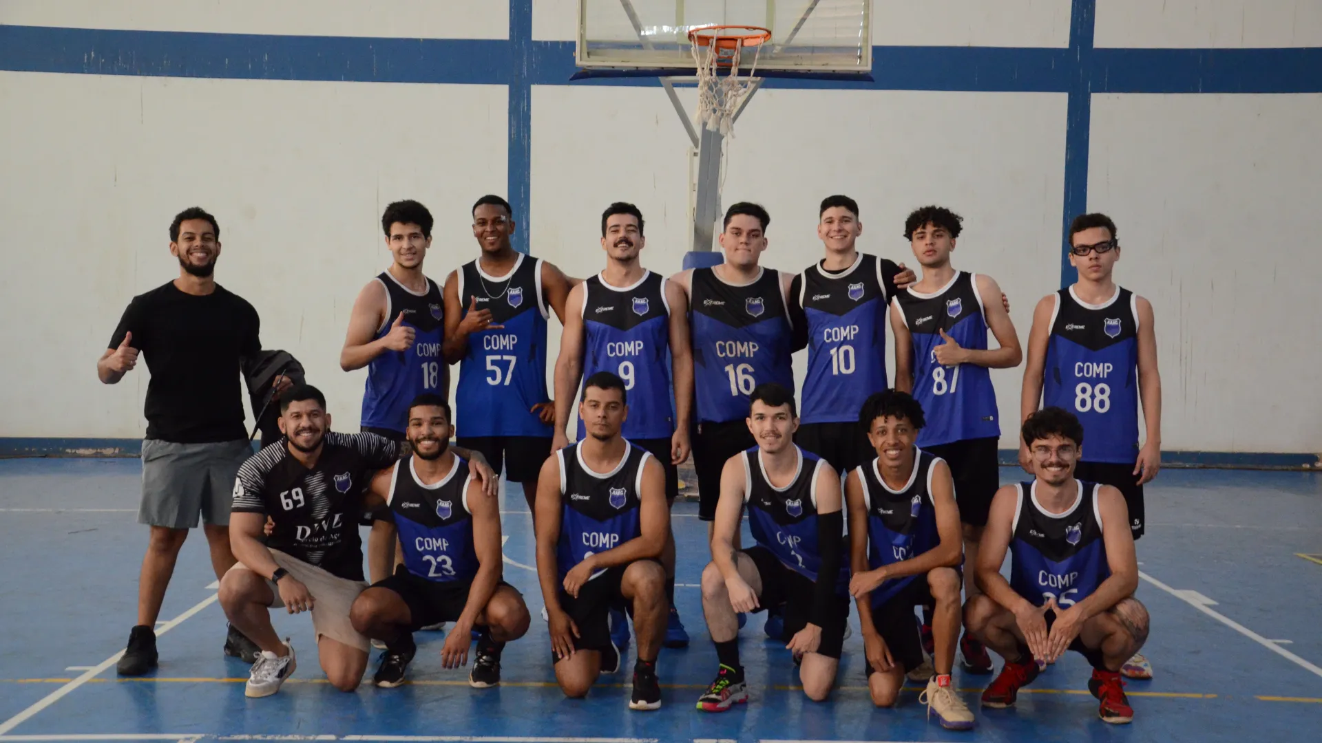 Time masculino de basquete da atlética Computação posicionados em duas filas. A de trás, em pé, e a da frente, ajoelhados