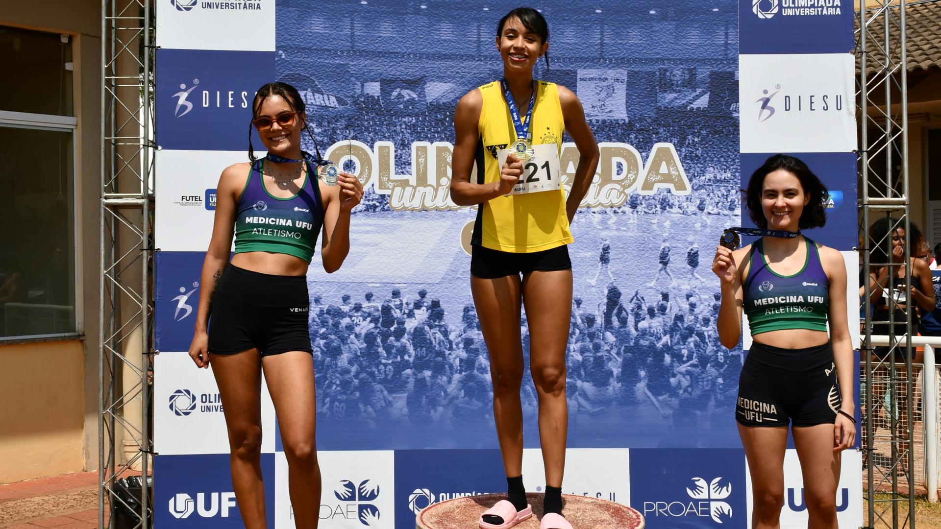 Estudantes-atletas no pódio do salto em distância feminino