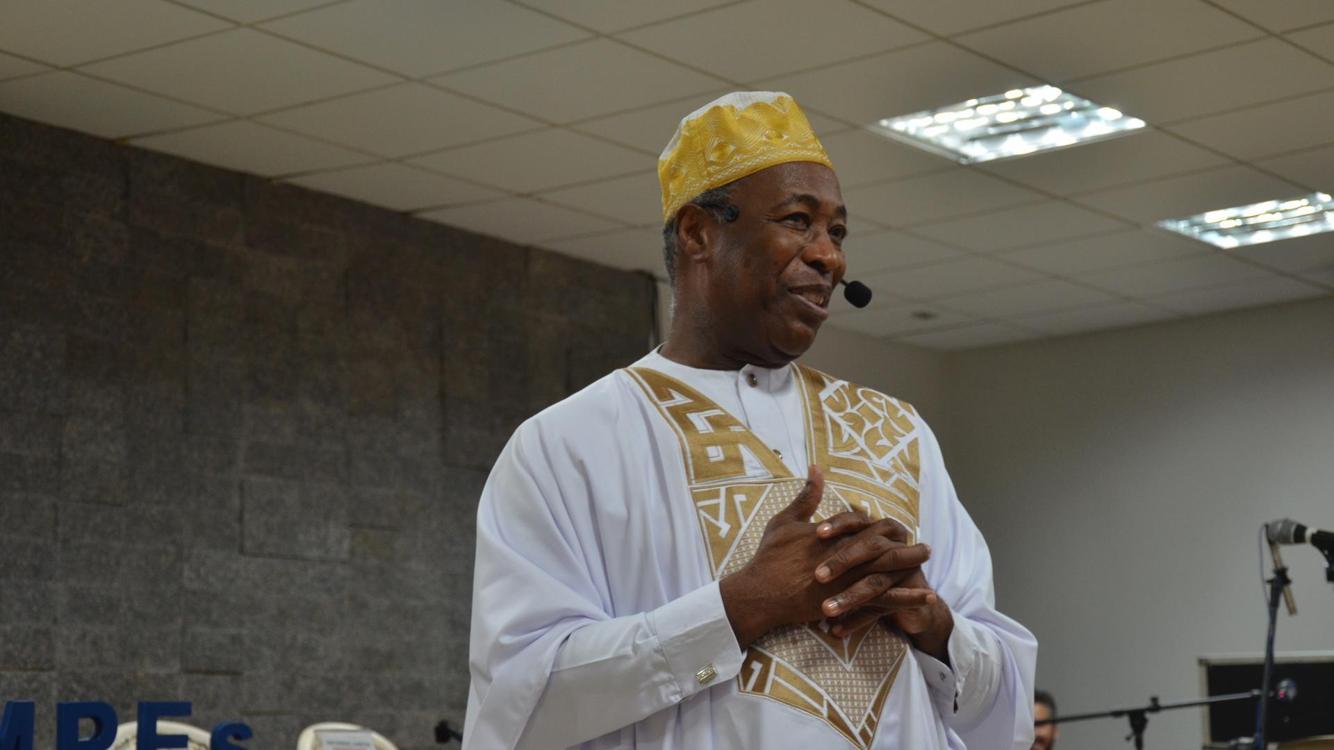 Vestido com trajes africanos, professor Natanael dos Santos fala durante a palestra