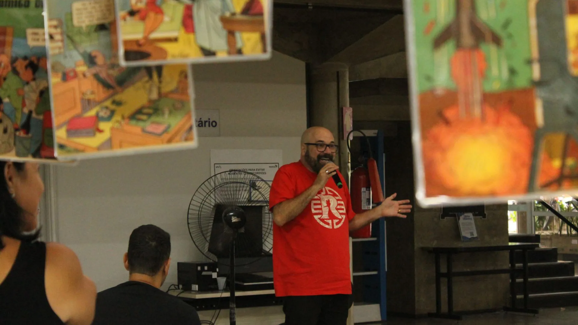 Maurício Ricardo, com o microfone na mão, falando aos ouvintes da palestra