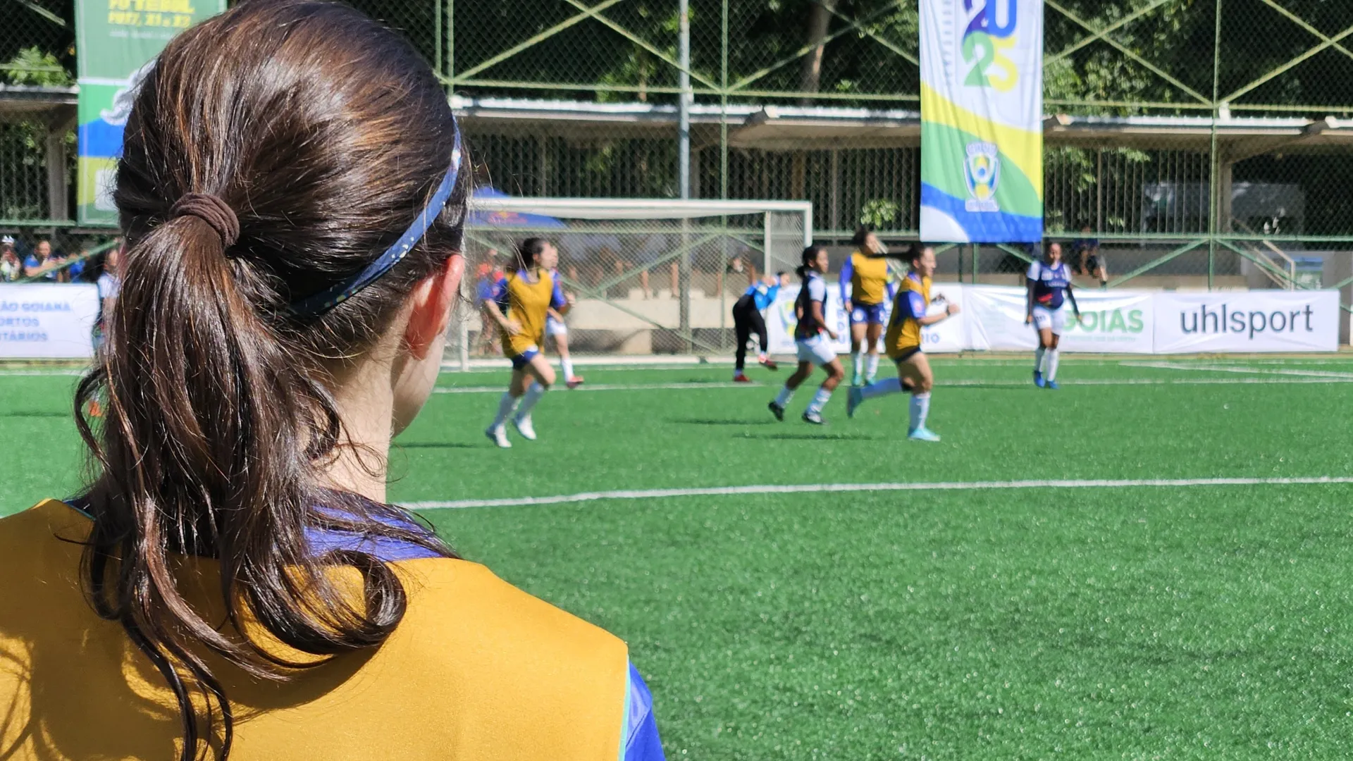 Jogadora olhando o time feminino de futebol jogar