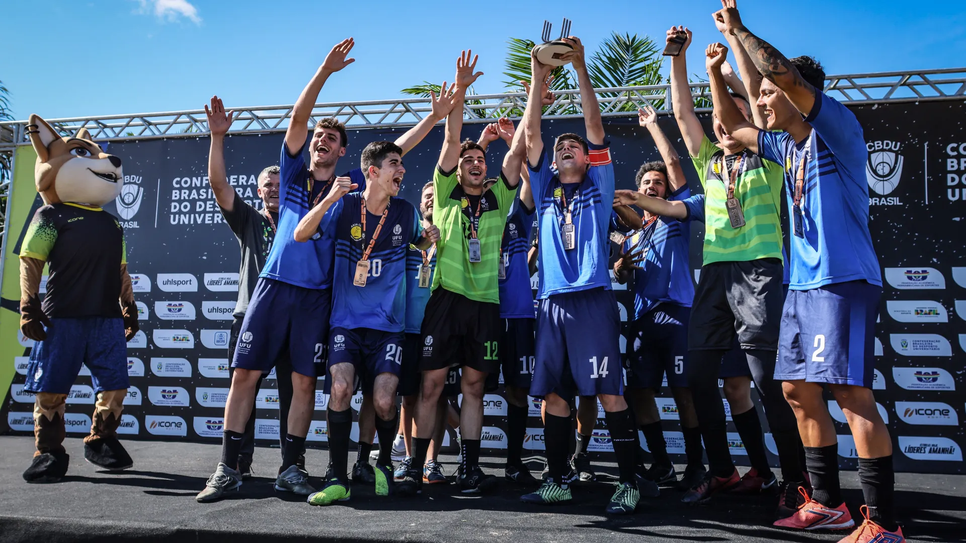 Estudantes-atletas do time de Futebol 7 da UFU no pódio, comemorando a conquista do terceiro lugar no JUBs Recife 2024