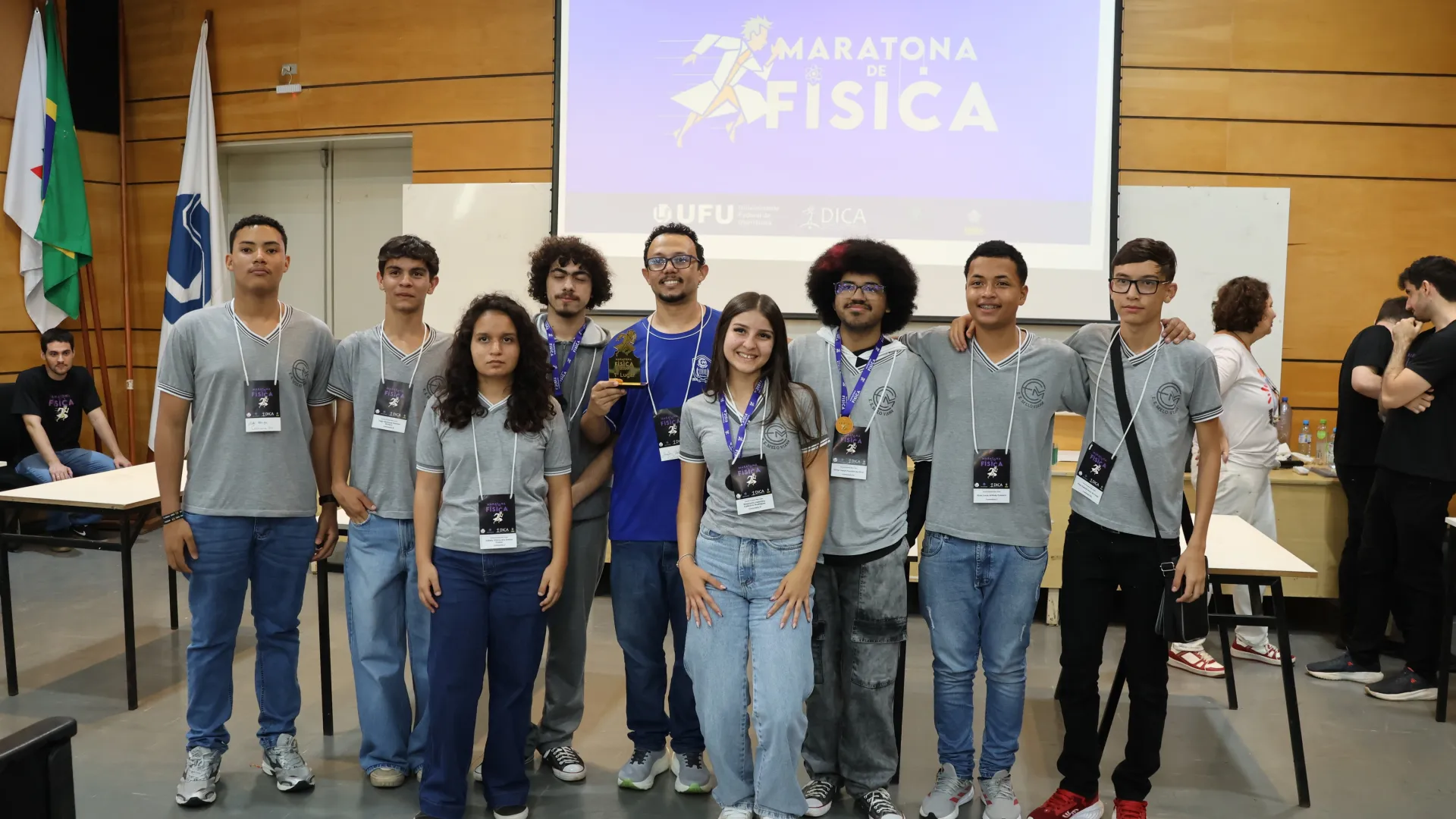 Estudantes da Escola Estadual Melo Viana reunidos, com o professor de Física e o troféu da competição