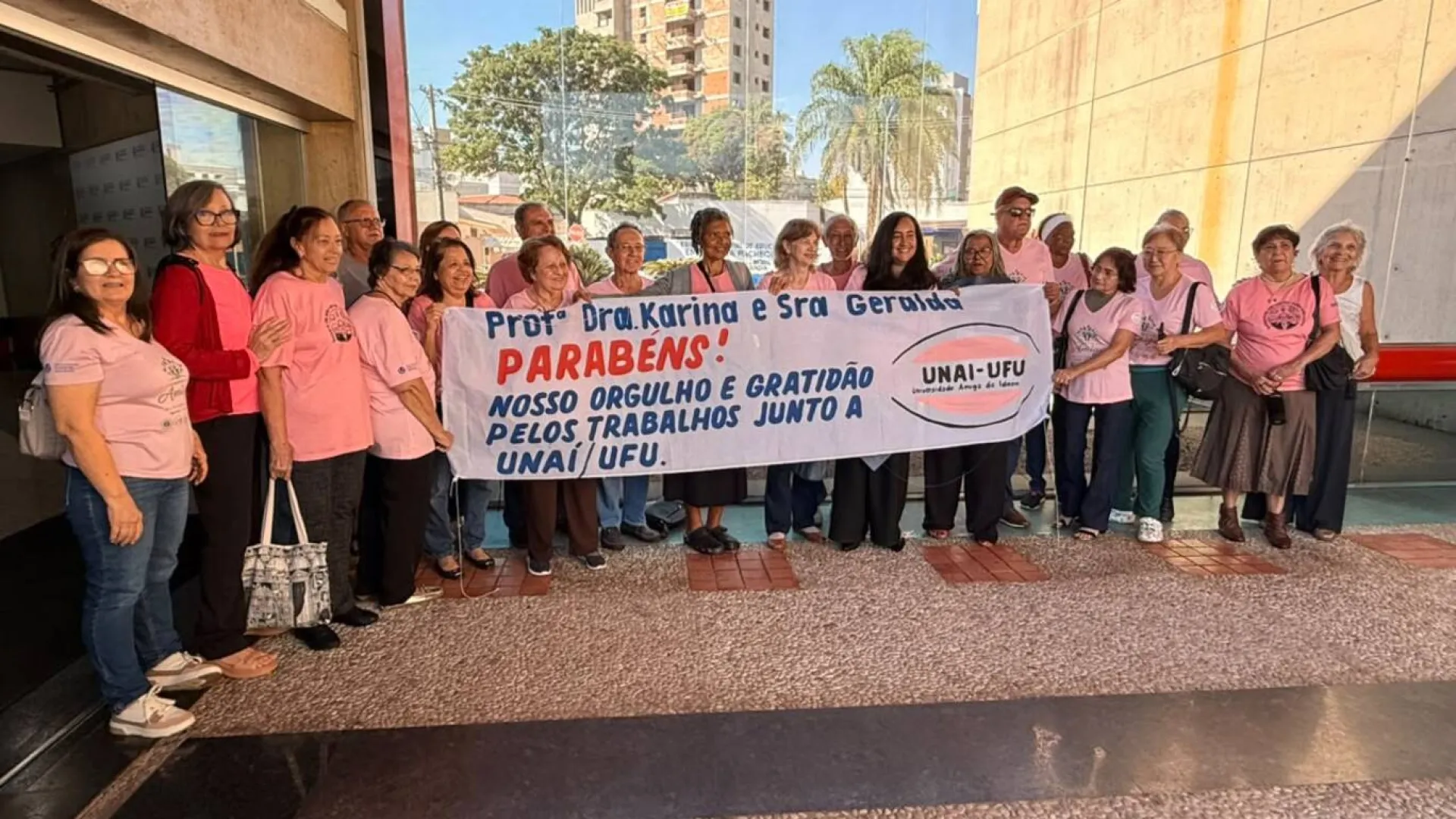 Imagem de pessoas do projeto "Universidade Amiga da Pessoa Idosa" segurando um cartaz de comemoração pelas homenagens
