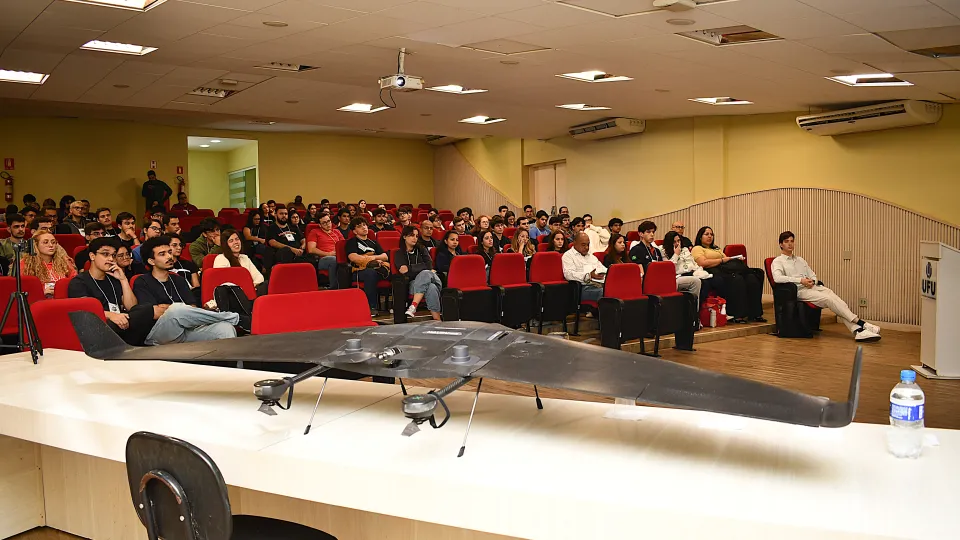 Foto da apresentação com um modelo aeronautico exposto para os estudantes