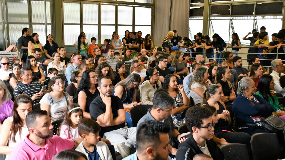 Há uma plateia de pessoas sentadas