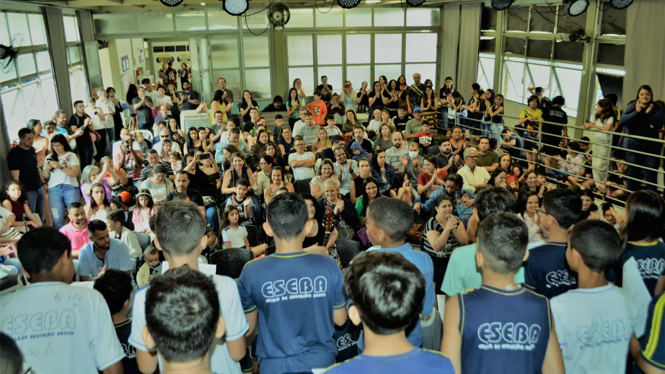 Alunos realizam uma apresentação em frente a uma plateia