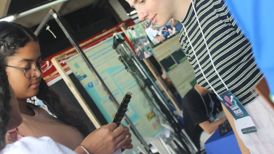 Menina segurando pena de pássaro do cerrado