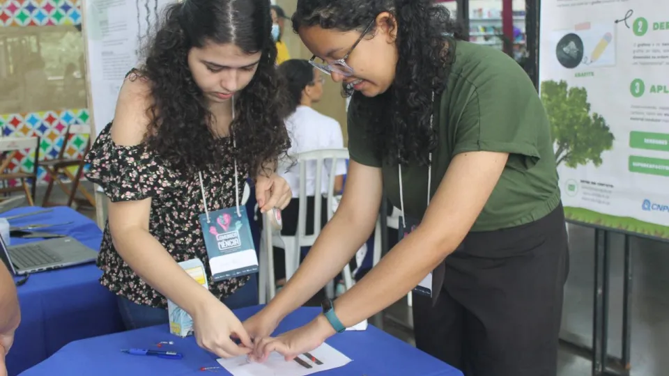 Estudantes arrumando mesa de sua mostra