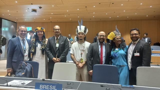 A foto mostra sete pessoas que formam parte da delegação brasileira e indígena