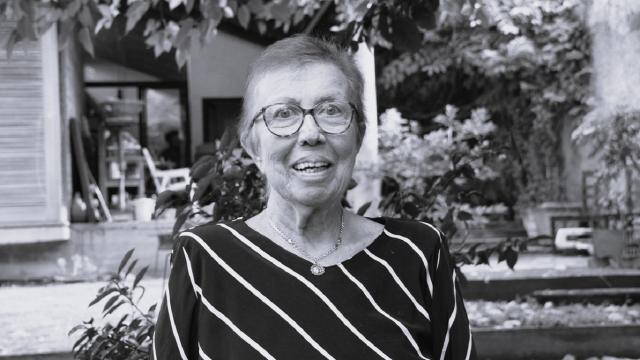 Foto de Marlene Colesanti, em preto e branco; ela usa óculos e cabelos curtos e aparece sorrindo