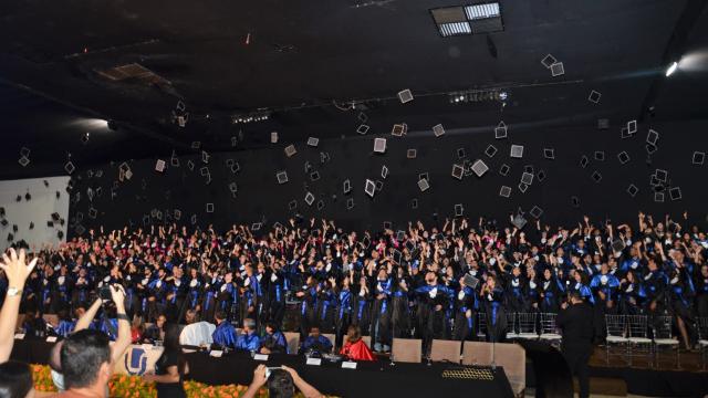 Foto de colação de grau da UFU, com formandos jogando seus capelos para o alto
