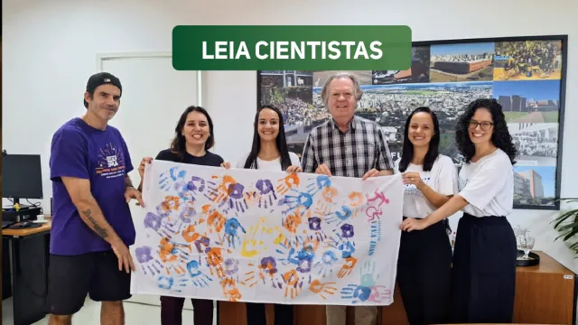 Pesquisadores segurando faixa