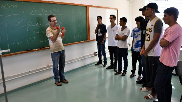 Professor apresentando o curso de graduação para alguns estudantes visitantes
