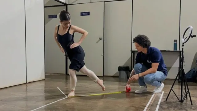 Foto de uma bailarina treinando com fisioterapeuta