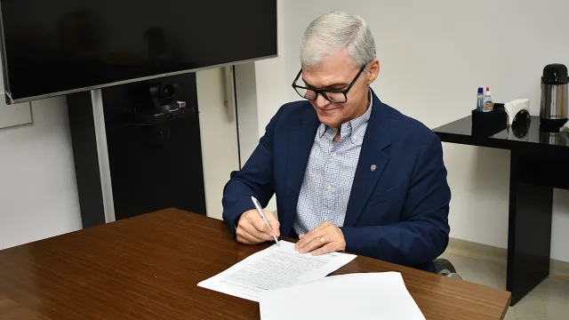 Reitor assinando o protocolo