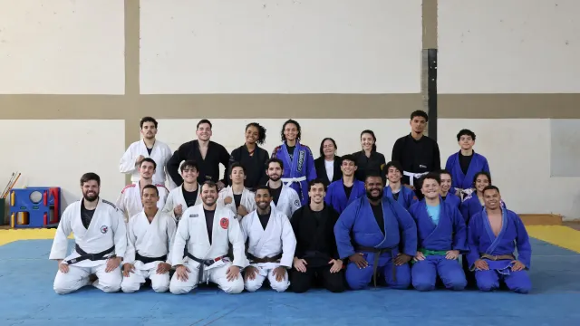 Estudantes da UFU alinhados em três fileiras após treino aberto de artes marciais
