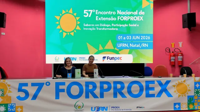 Foto de Valéria Rodrigues e Gláucia Carvalho, sentadas à mesa do 57º FORPROEX