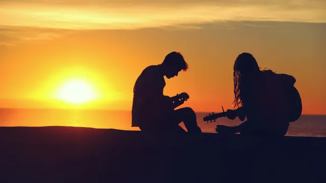 Imagem ilustrativa com duas pessoas tocando violão e, ao fundo, 